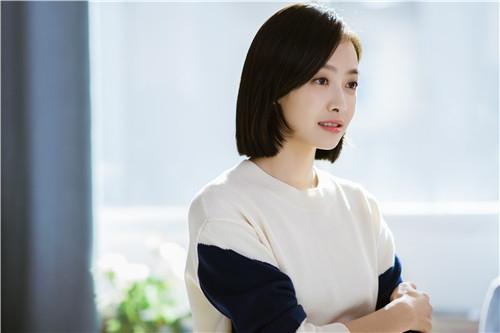 王李丹妮在电视剧中饰演职场女性的剧照，表情干练